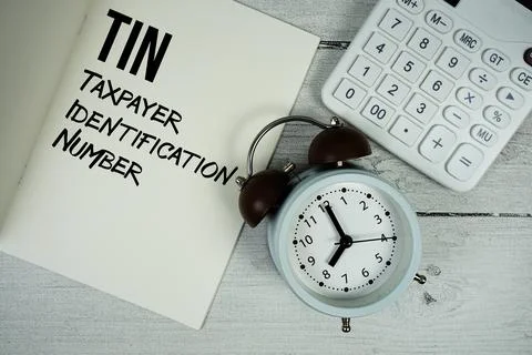 TIN Taxpayer Identification Number text on paper notebook page with alarm c.. Stock Photos