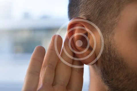 Tinnitus. Young man with hearing problems or hearing loss. Hearing test concept. Stock Photos