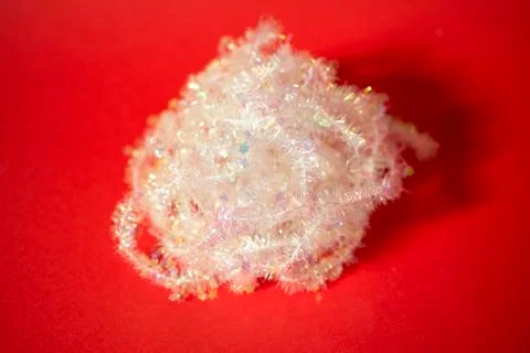 Tinsel wrapped up on red background Stock Photos