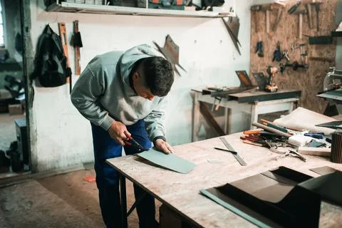 Tinsmith blacksmith use hammer working in his workshop. Stock Photos