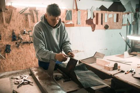 Tinsmith blacksmith use hammer working in his workshop. Stock Photos