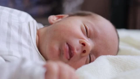 Tiny and fragile infant resting peacefully his tiny chest rising and falling 動画素材 291550637