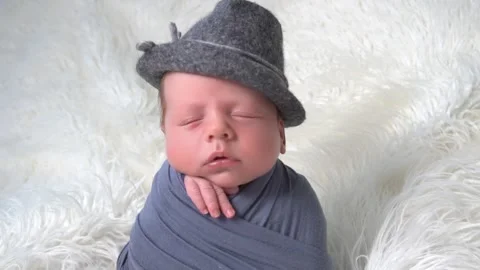 Tiny baby with beautiful hat in wrap lies on the soft fluffy blanket. 스톡 동영상 153760447
