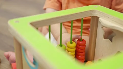 Tiny baby kid toddler hands playing colorful wooden abacus toy Stock Footage 165045991