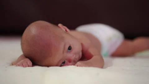 Tiny baby lies on soft white blanket Stock Footage 340312011