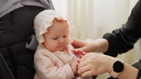 A tiny baby sits in a stroller and sucks a pacifier Video stock 247113922