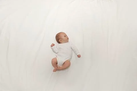 Tiny baby on spacious bed Stock Photos
