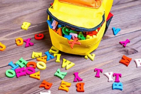Tiny Backpack and Wooden Letters on a Wooden Table Stock-Fotos