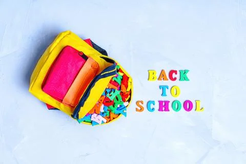Tiny Backpack Stuffed with Vibrant Wooden Letters Stockfoto's