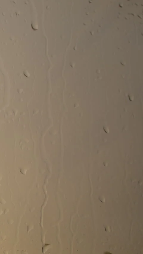 Tiny beads of water make their way down the slick surface of the window Video stock 242026492