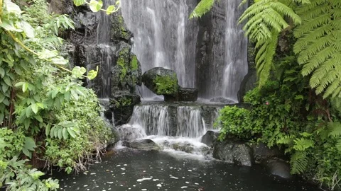A tiny beautiful artificial waterfall in a garden. Stock Footage 81641185