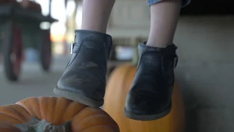 Tiny Black Boots Gently Kicking a Pumpkin Stock Footage 210218630