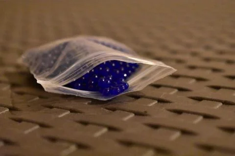 Tiny Blue Orbs in a Plastic Pouch Foto stock
