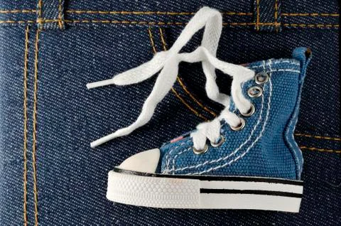 Tiny blue shoe on denim background Stock-Fotos