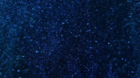 Tiny blue spheres rise against a black background.  These bubbles are Stock Footage 126150530