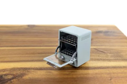 Tiny blue toy oven with open door on a cutting board Foto stock
