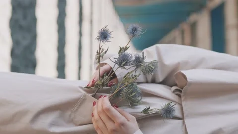 A tiny bouquet of field flowers in pocket of woman's coat Stock Footage 158423666