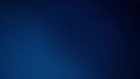 Tiny bright particles slowly swirl across a dark blue background Stock Footage 340831643