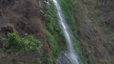 Tiny bright waterfall shining &amp; falling in the dark forest background. Video stock 278545092