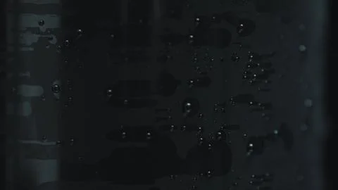 Tiny bubbles rising on dark background creating abstract pattern Stock Photos