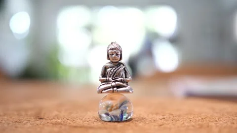 Tiny Buddha in focus with a man in the background doing various house chores Vidéo 278482795