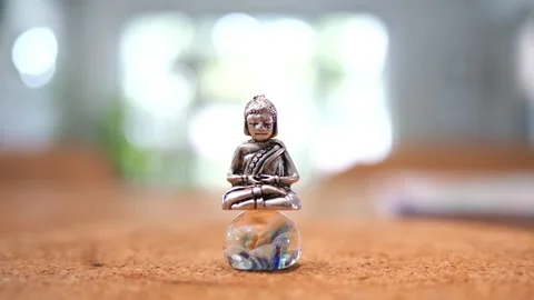 Tiny Buddha in focus with a man in the background doing various house chores Vidéo 278482815