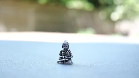 Tiny Buddha in focus with a man in the background doing various house chores Vidéo 278544258