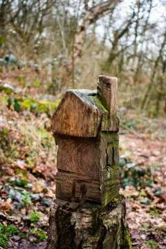 A tiny carved house on a tree stump 库存照片