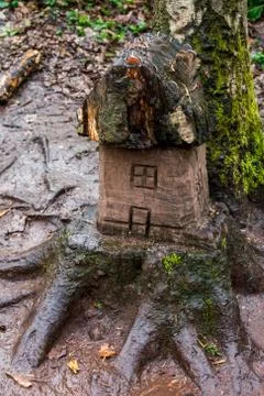 A tiny carved house on a tree stump Stock Photos