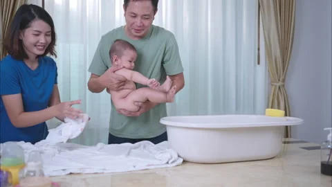 A tiny child happily on the towel waiting for parents apply powder Stock Footage 291651278