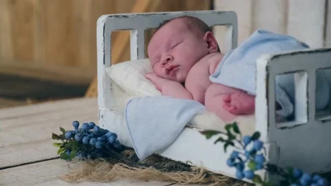 Tiny child is sleeping in a small vintage bed while shooting. Photographing a Stock Footage 172283516
