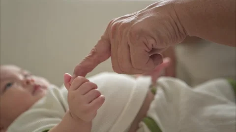 A tiny child smiling happily on the couch with grandfather Stock Footage 288109773