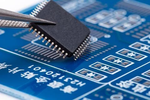 Tiny chip rests on circuit board's surface Stock Photos