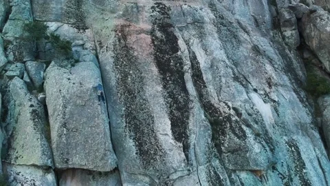A tiny climber is stuck on a tricky step on a granite wall Video stock 138905969