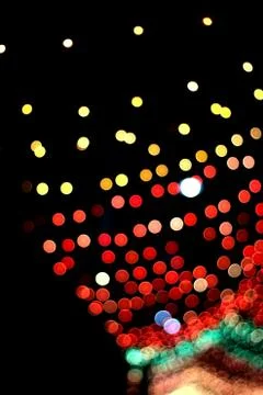 Tiny colorful blurred light bokeh background at night with black background i Stock Photos