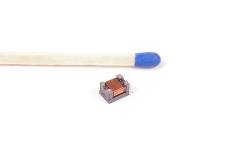 Tiny common mode choke filter in comparison with match head Stock-Fotos