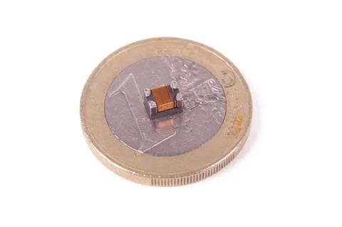 Tiny common mode choke filter in comparison with 1 euro coin Stock Photos