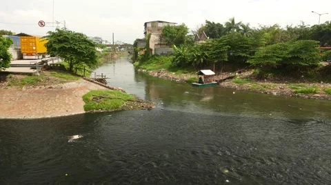 Tiny covered raft serves as cable ferry across polluted river stream 動画素材 51554071