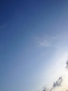 Tiny crescent moon up in the bright blue Stock Photos