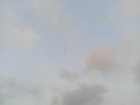 Tiny crescent moon on cloudy afternoon sky Stock Photos