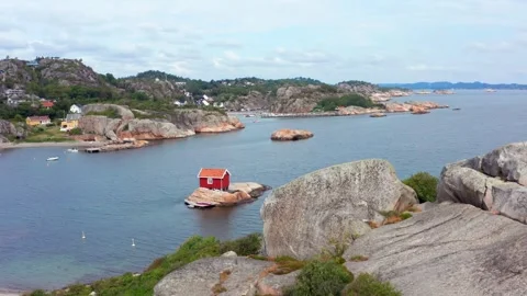 Tiny cute summer house cabin in red. Small building on secluded island big rock Stock Footage 319687251