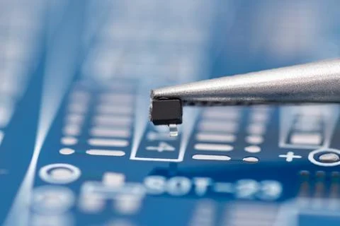 Tiny electronic component rests on a circuit board Stock Photos