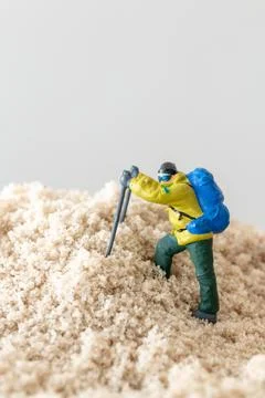 Tiny Explorer Figurine on Mountain Concept Stock Photos