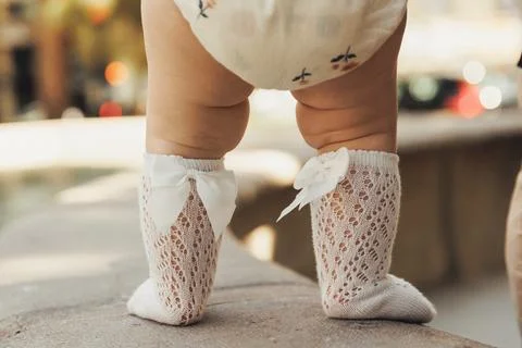 Tiny feet in delicate lace socks with bows Stock-Fotos