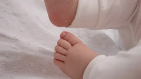 Tiny feet of newborn child boy not wearing socks and mp4ing them really fast. Stock Footage 302452727