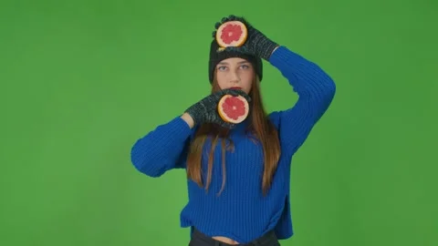 Tiny female character rolling grapefruit slice dresses in blue sweater and Stock Footage 157938325