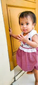Tiny Female Toddler Crawling on Front Entryway Cement Without Toys Stock-Fotos