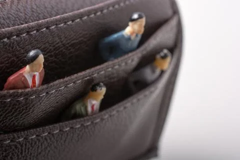 Tiny figurine of group of men miniature model in pockets Stock Photos
