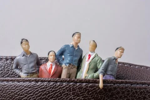 Tiny figurine of group of men miniature model in pockets Foto stock