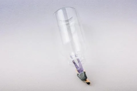 Tiny figurine of man miniature model coming out of bottle Foto stock